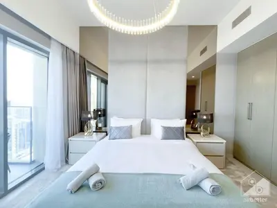 a bedroom with a large white bed with a chandelier at Luxury Burj Royale Apt balcony & Breathtaking View in Dubai
