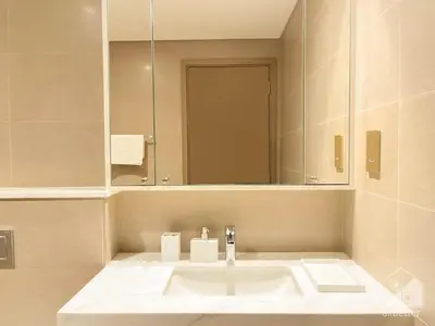 a bathroom with a white sink and a mirror at Luxury Burj Royale Apt balcony & Breathtaking View in Dubai