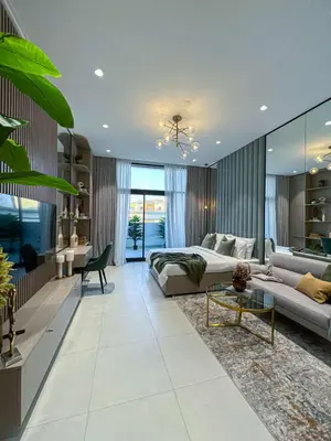 a living room with a bed and a couch at Bright New Studio with Pool & Gym Access, 5 min from Gardens Metro in Dubai