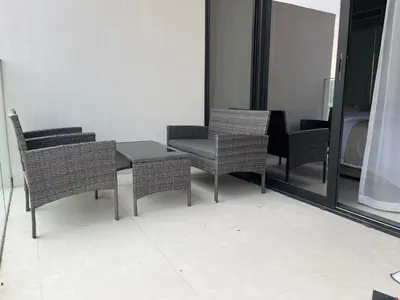a room with a table and chairs and a mirror at Bright New Studio with Pool & Gym Access, 5 min from Gardens Metro in Dubai