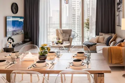 a living room with a table and chairs at Brand new 2 BR in Boulevard with partial Burj Khalifa and Opera View in Dubai