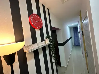 a red clock on the wall of a hallway at Striped Partition Room in Barsha 1 Near Mall of the Emirates in Dubai
