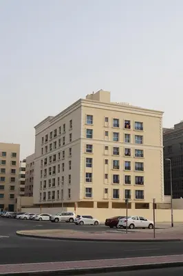 a large building with cars parked in a parking lot at Striped Partition Room in Barsha 1 Near Mall of the Emirates in Dubai