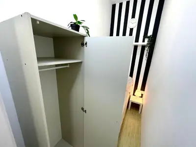 a white cabinet in a room with a staircase at Striped Partition Room in Barsha 1 Near Mall of the Emirates in Dubai
