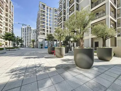 a row of large concrete planters with trees in a street at Summer at Creek Beach - Elegant One Bedroom in Dubai