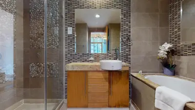 a bathroom with a tub and a sink and a mirror at Iris Blue - Neat One Bedroom in Dubai