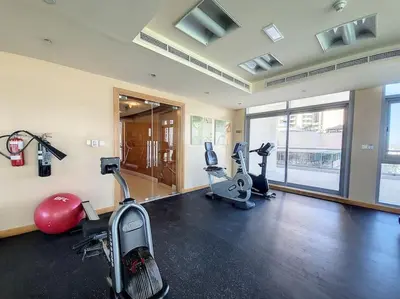 a gym with treadmills and exercise bikes in a room at Iris Blue - Neat One Bedroom in Dubai