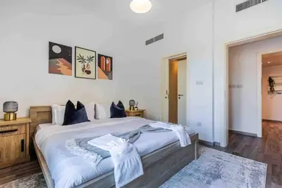 a bedroom with a large bed with blue pillows at Serene & Spacious 1BR The Greens in Dubai