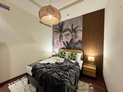 a bedroom with a bed and a painting on the wall at Manzil - 3BR in Palm Jumeirah with Private Beach Access & Sea View in Dubai