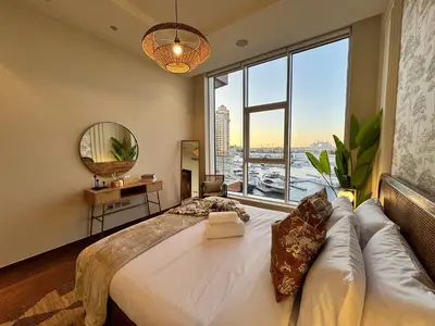 a bedroom with a large bed with a large window at Manzil - 3BR in Palm Jumeirah with Private Beach Access & Sea View in Dubai