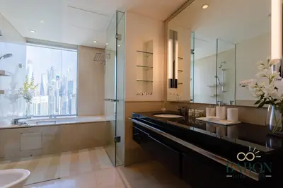 a bathroom with a sink and a glass shower at The Sophisticated Suite in Dubai