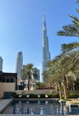 a view of the burj khalifa from the pool with palm trees at SmartApt Elegant 1 BDR Burj view in Dubai
