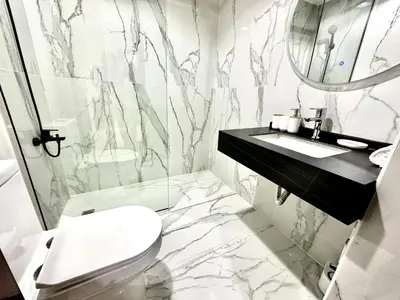 a bathroom with a toilet and a sink and a mirror at Elegant 2 BR in Dubai Marina walking Metro & Beach- Marina Park in Dubai