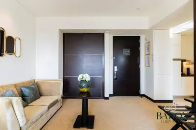 a living room with a couch and a vase of flowers on a table at The Stylish in Dubai