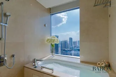 a bathroom with a bath tub with a window at The Stylish in Dubai