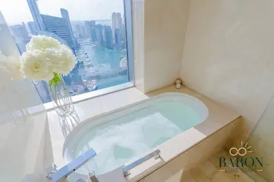 a bathroom with a tub with a vase of flowers at The Stylish in Dubai