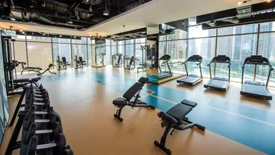 a gym with treadmills and elliptical machines at Luxe Living: Spacious Waterfront 2BR in Marina Gate in Dubai