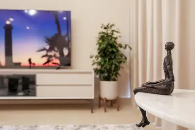a living room with a tv and a statue at Luxe Living: Spacious Waterfront 2BR in Marina Gate in Dubai