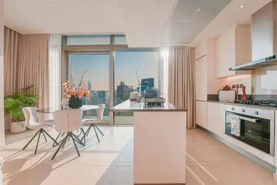a kitchen with a table and chairs and a large window at Luxe Living: Spacious Waterfront 2BR in Marina Gate in Dubai
