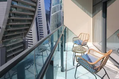 a balcony with two chairs and a table at Studio Apartment in Merano Tower by The S Holiday Homes in Dubai