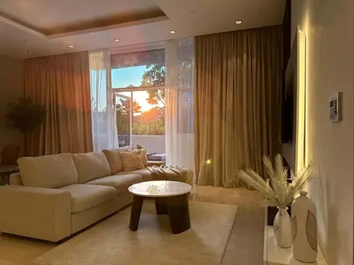 a living room with a couch and a table at Upgraded 1BR Paradise With Private Garden - Oceana in Dubai