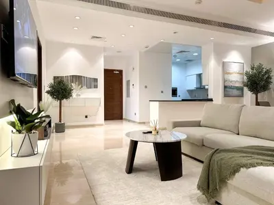 a living room with a couch and a table at Upgraded 1BR Paradise With Private Garden - Oceana in Dubai