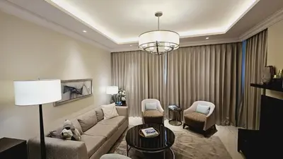 a living room with a couch and chairs and a chandelier at Address Fountain View Tower 2 in Dubai