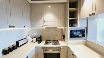 a kitchen with a stove and a microwave at Address Fountain View Tower 2 in Dubai