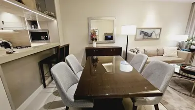 a living room with a table and chairs in a room at Address Fountain View Tower 2 in Dubai