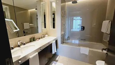 a bathroom with two sinks and a shower and a tub at Address Fountain View Tower 2 in Dubai