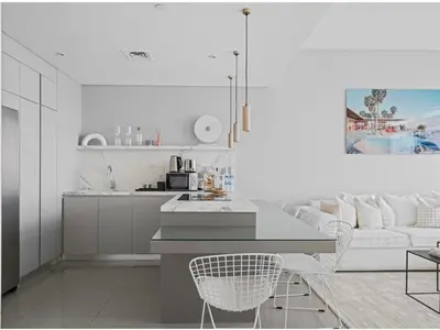 a white kitchen with a couch and a table at Palm View - Beach Vista T1 in Dubai