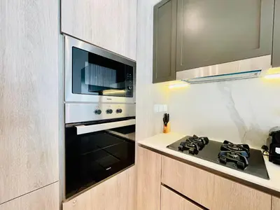 a kitchen with a stove and a microwave at Brand New Luxury 1 Bedroom Apartment in Dubai