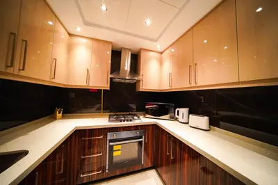 a kitchen with wooden cabinets and a stove top oven at Unforgettable 1BR Mesmerizing Burj Khalifa Views - 17AB02 in Dubai