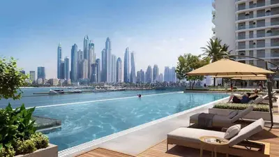a pool with a city skyline in the background at Beachfront Bliss - Apartment with Pool and Premium Amenities By ĀYA Boutique in Dubai