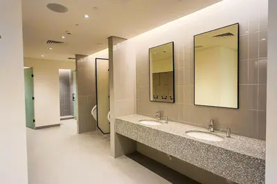 a public bathroom with two sinks and two mirrors at Beachfront Bliss - Apartment with Pool and Premium Amenities By ĀYA Boutique in Dubai