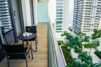 a balcony with a table and chairs in a building at Beachfront Bliss - Apartment with Pool and Premium Amenities By ĀYA Boutique in Dubai