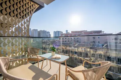 a balcony with a table and chairs and a view of a city at GuestReady - A beautiful home in Jumeirah Village in Dubai