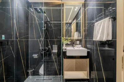 a bathroom with a sink and a shower with black tiles at GuestReady - A beautiful home in Jumeirah Village in Dubai