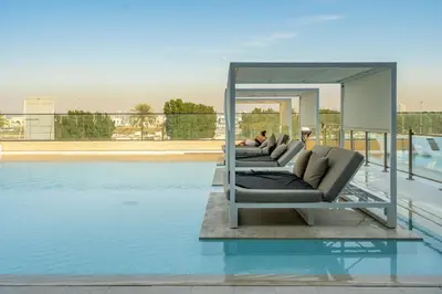a row of chairs sitting on top of a swimming pool at GuestReady - A beautiful home in Jumeirah Village in Dubai