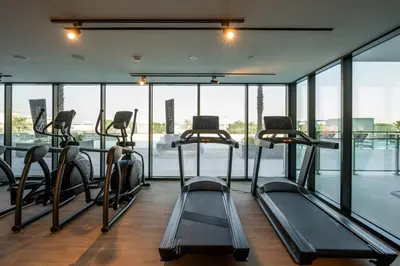 a gym with several treadmills in a room with windows at GuestReady - A beautiful home in Jumeirah Village in Dubai