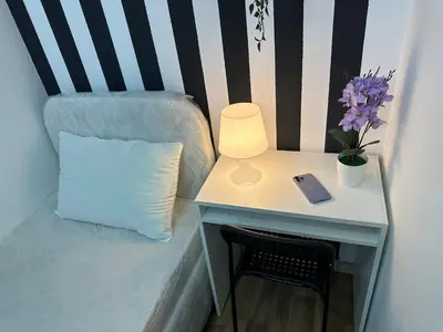 a table with a lamp and a chair with a pillow at Lovely Private Partition Room in Barsha Heights in Dubai