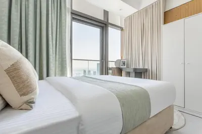 a bedroom with a white bed with a large window at Frank Porter - Paramount in Dubai