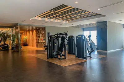 a gym with treadmills and ellipticals in a room at Frank Porter - Paramount in Dubai