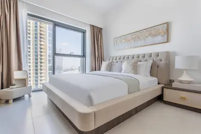 a bedroom with a large bed and a large window at Frank Porter - Burj Royale in Dubai