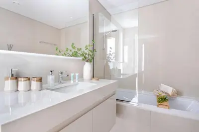 a white bathroom with a sink and a tub at Frank Porter - Burj Royale in Dubai