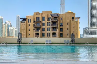 a swimming pool with chairs in front of a building at Frank Porter - Burj Royale in Dubai