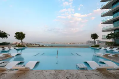 a swimming pool with lounge chairs on a building at Fully Furnished - 1 BR - Palm View with Beach Access in Dubai