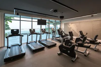a gym with cardio equipment in a room with a large window at Fully Furnished - 1 BR - Palm View with Beach Access in Dubai
