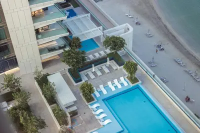 an overhead view of a building with a swimming pool at Fully Furnished - 1 BR - Palm View with Beach Access in Dubai