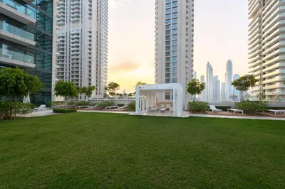 a park in the middle of a city with tall buildings at Fully Furnished - 1 BR - Palm View with Beach Access in Dubai